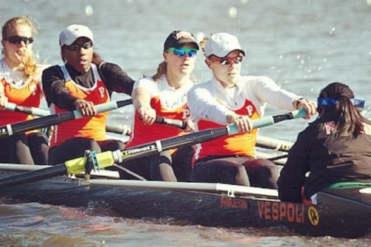 Five women row crew on a river.