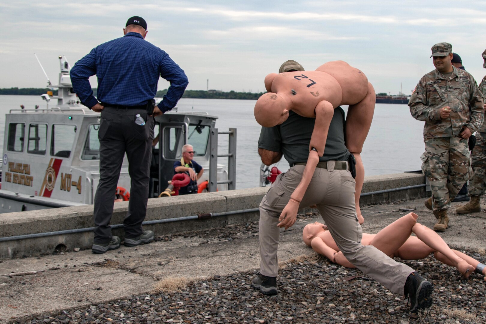 Philadelphia firefighters, along with U.S. Army North personnel and Task Force 46 Soldiers, deliver a notional victim to mass casualty decontamination personnel.