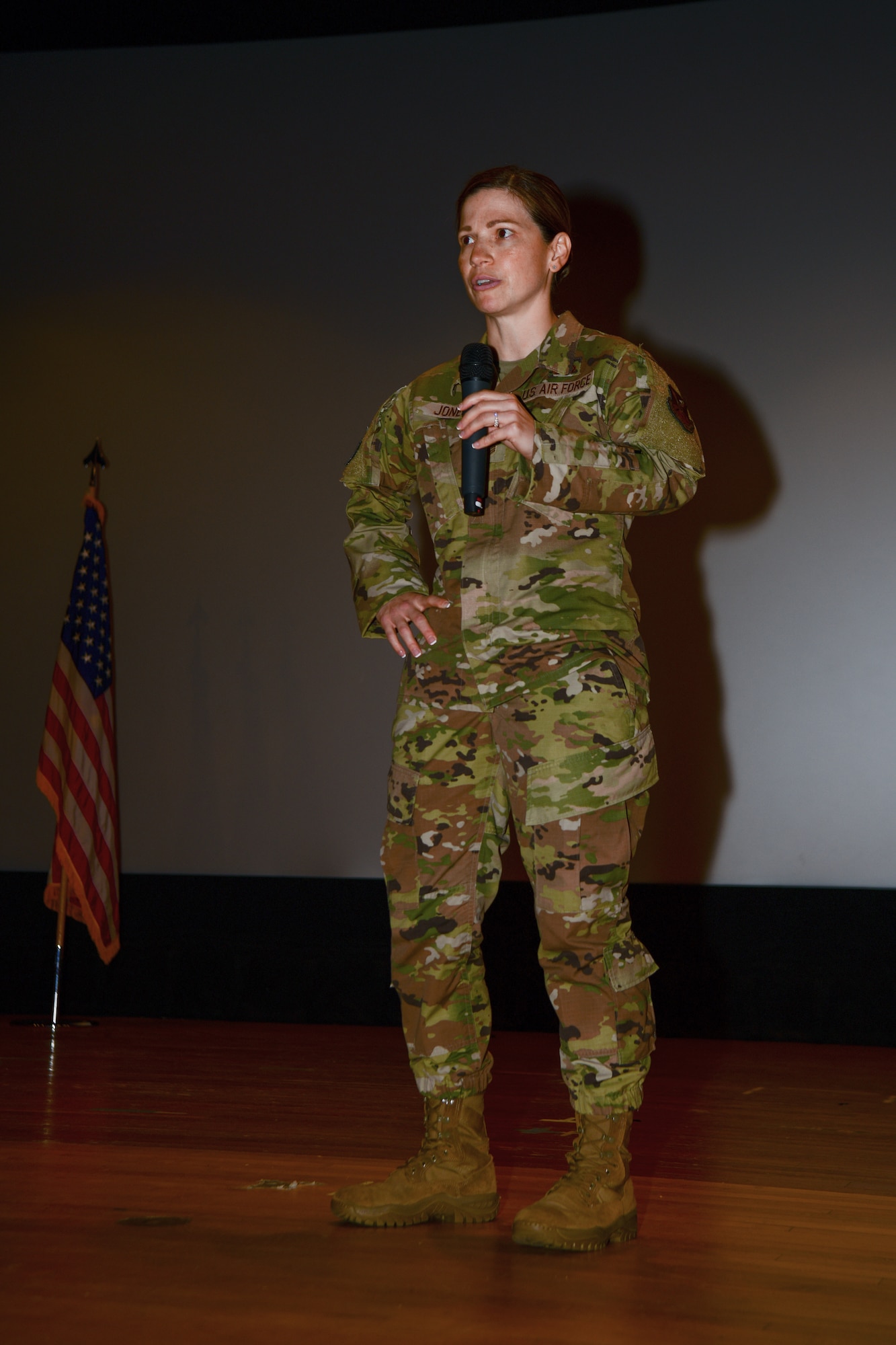 Chief Master Sgt. Tori Jones, 5th Bomb Wing Command Chief, talks at an all call at the base theater on Minot Air Force Base, North Dakota, July 25, 2022. Part of Jones' job is to advocate for the Airmen’s professional development, health, welfare, discipline and quality of life at Minot AFB. (U.S. Air Force photo by Airman Alysa Knott)