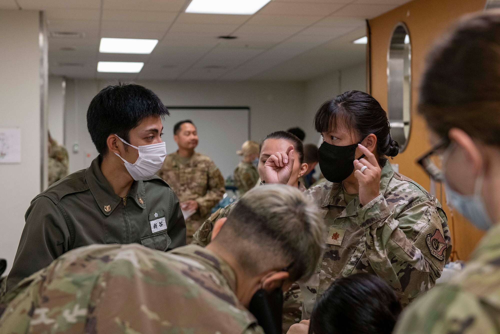 A U.S. Air Force Airman explains medical procedures to students