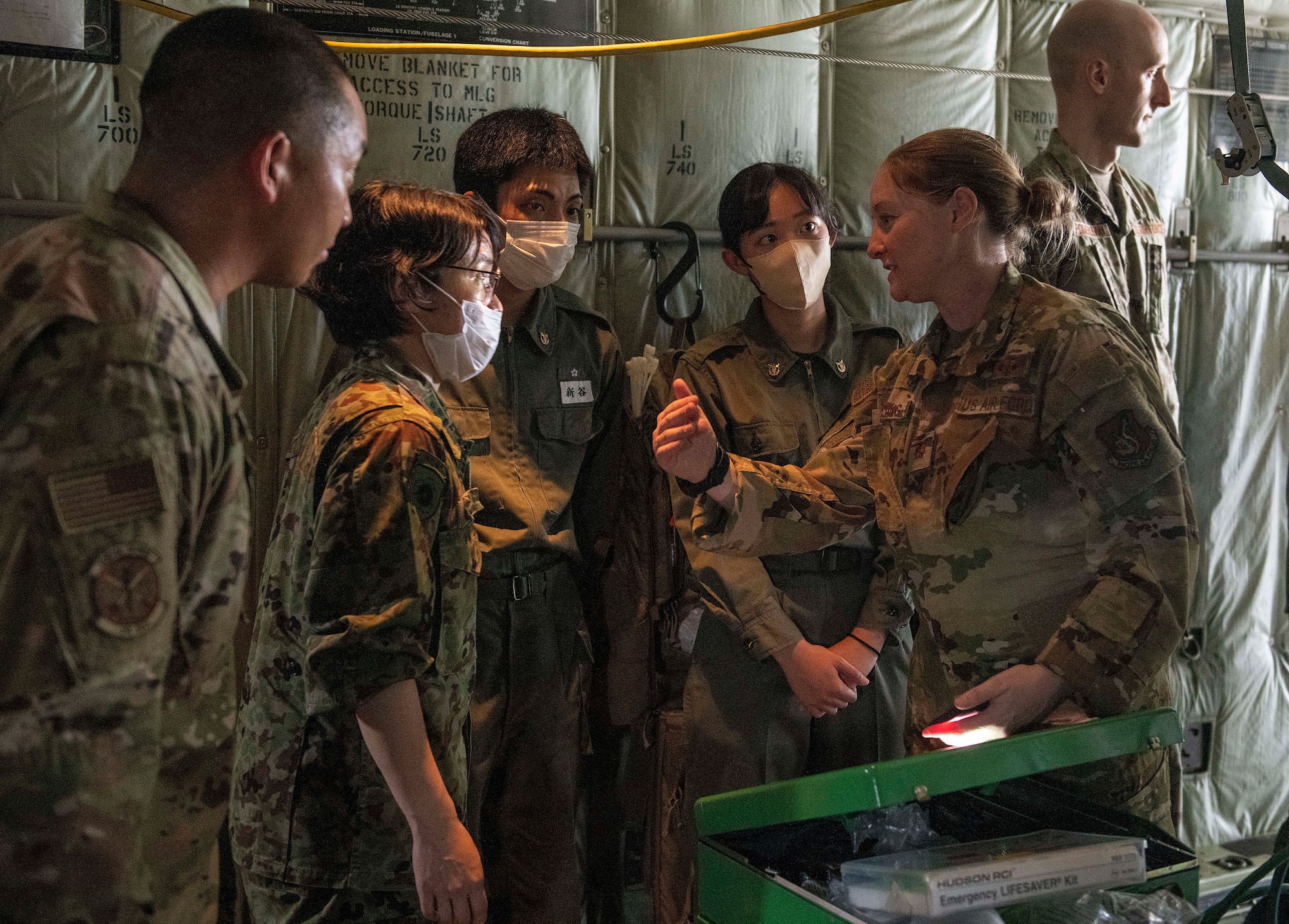 A U.S. Air Force Airman explains patient transport capabilities in a C-130J Super Hercules for students and instructors