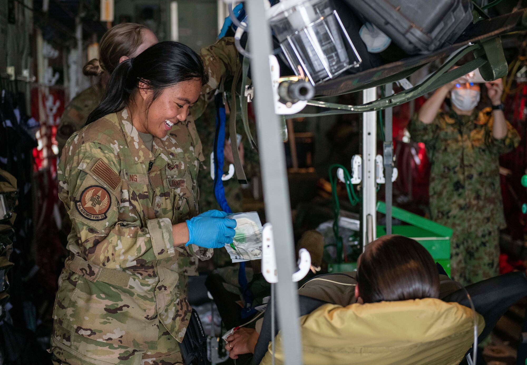 A U.S. Air Force Airman demonstrates simulated patient treatment in a C-130J Super Hercules for students and instructors