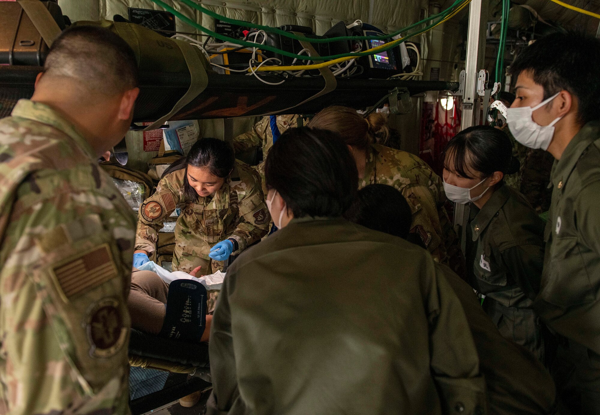 Students and instructors watch as a U.S. Air Force Airman demonstrates simulated patient treatment