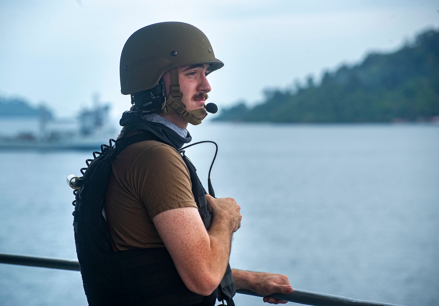 KOTA KINABALU, Malaysia (July 17, 2022) Gunner’s Mate 3rd Class Christian Freda, from Long Island, New York, assigned to the Emory S. Land-class submarine tender USS Frank Cable (AS 40), stands watch as the ship departs from Sepanggar Naval Base in Kota Kinabalu, Malaysia, July 17, 2022.  Frank Cable is currently on patrol conducting expeditionary maintenance and logistics in support of a free Indo-Pacific in the U.S. 7th Fleet area of operations. (U.S. Navy photo by Mass Communication Specialist 3rd Class Wendy Arauz)