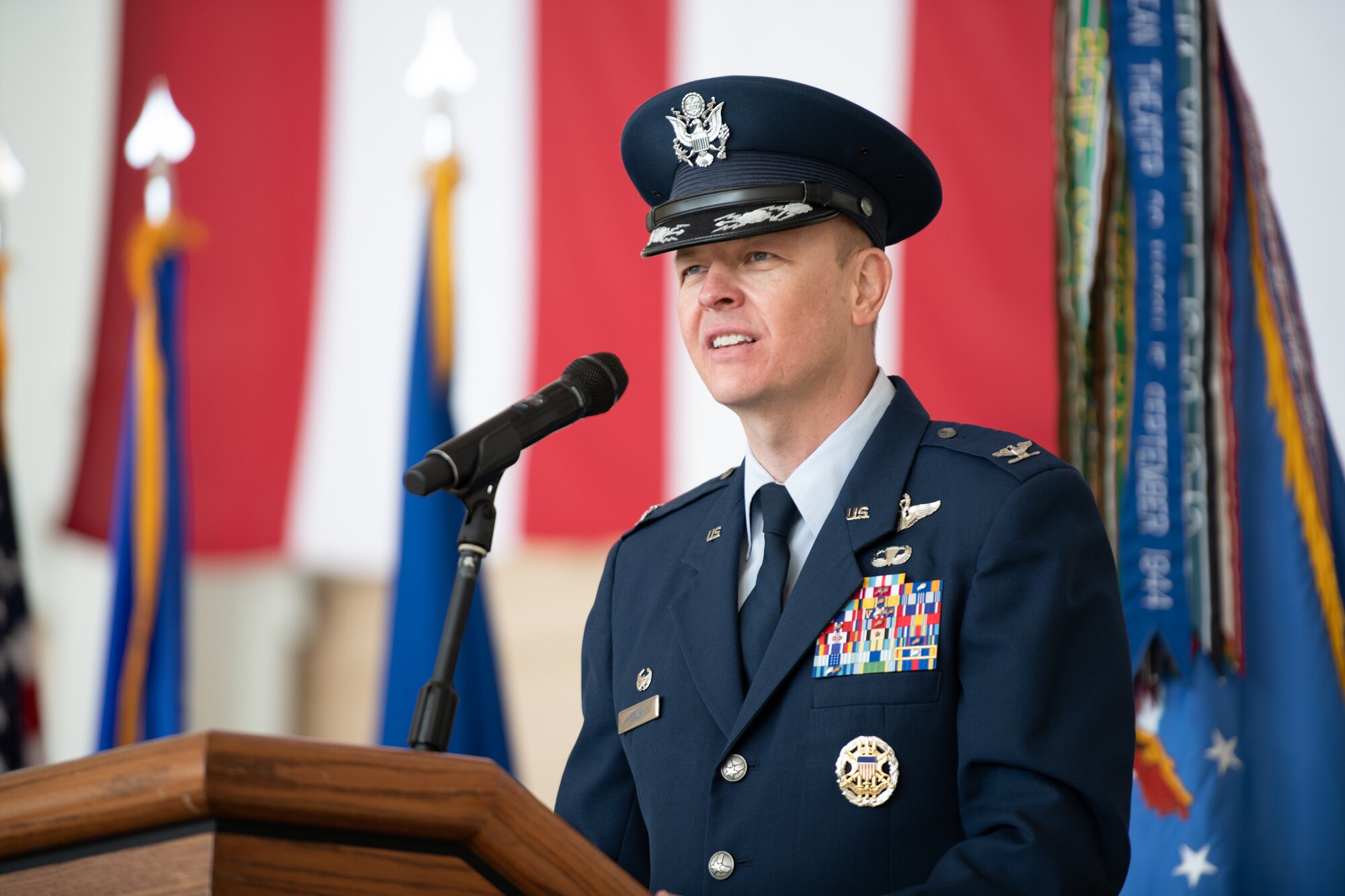 An higher ranking Airman talks at a microphone.