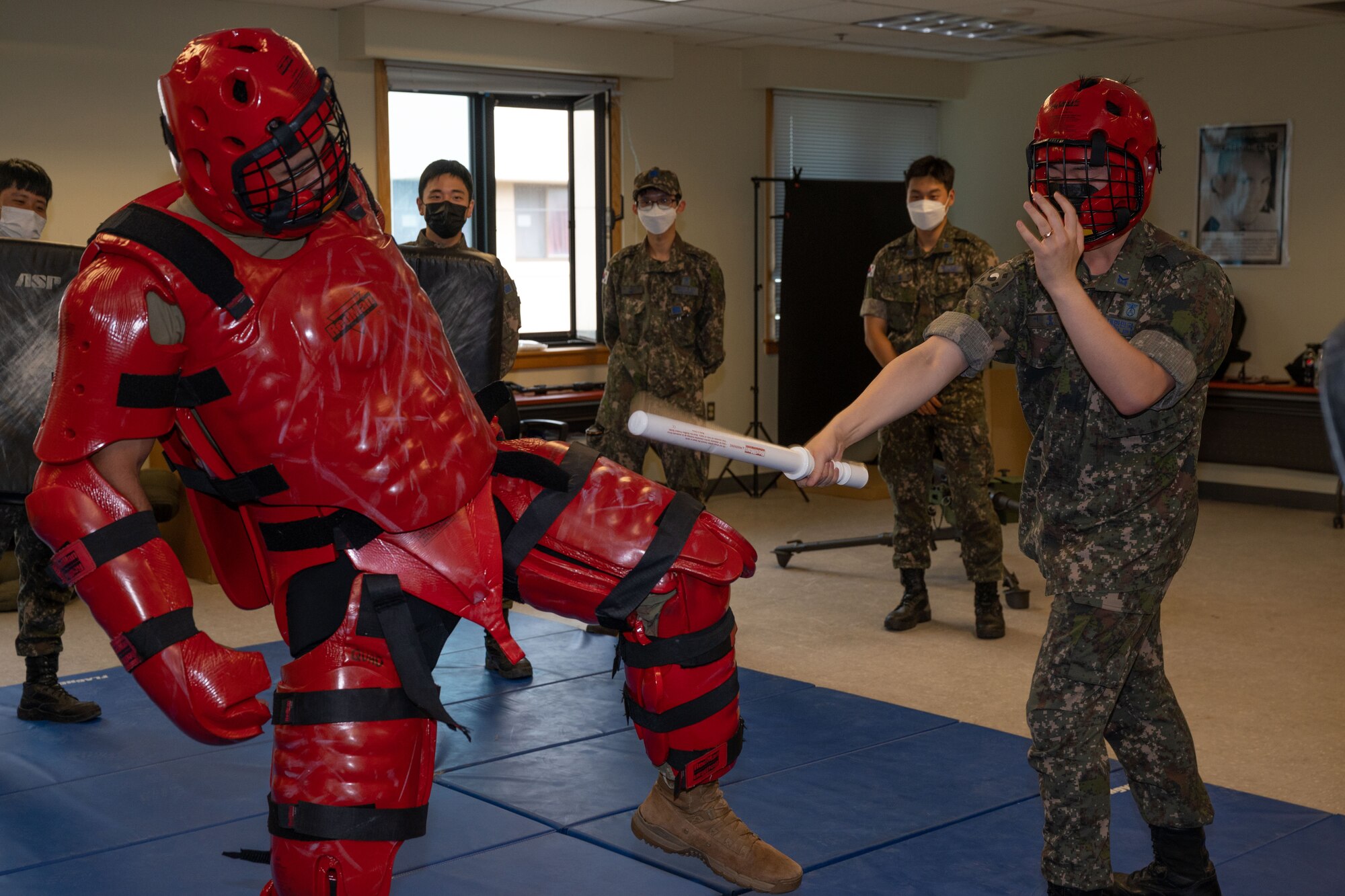 An USAF Airman wear red sparring gear trains against an Airman from ROKAF