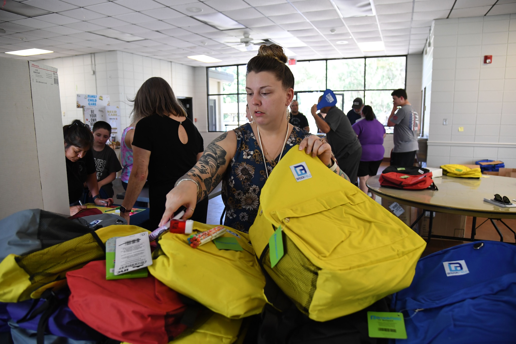 Jennifer Guy, 81st Training Wing civilian health promotion services specialist, packs supplies into a bookbag during a Back to School Bash at the Keesler Marina on Keesler Air Force Base, Mississippi, July 28, 2022. The bash, a collaboration of agencies that included Operation Homefront, the Back-to-School Brigade and Keesler support agencies, provided families with nearly 200 bookbags filled with supplies and included games and free snow cones. (U.S. Air Force photo by Kemberly Groue)