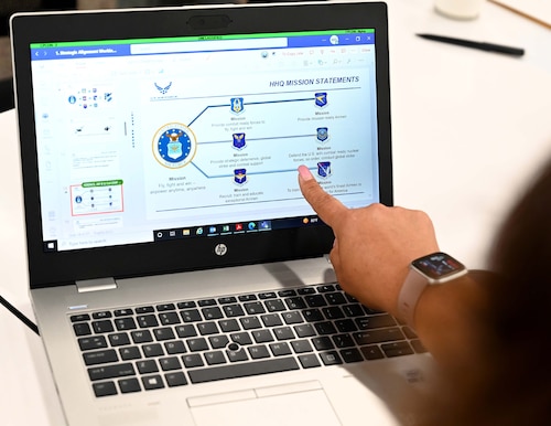a woman points to a computer screen