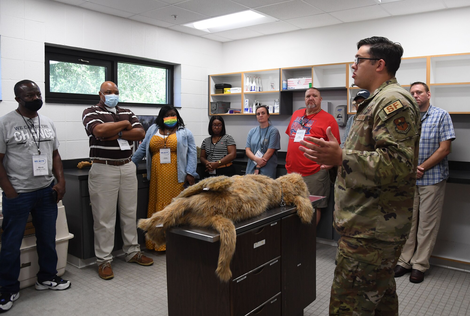 U.S. Air Force Staff Sgt. Cody Garton, 81st Security Forces Squadron military working dog handler, provides a tour inside the K-9 kennel during the Mississippi Educators Tour for Law and Public Safety and Fire Science tour at Keesler Air Force Base, Mississippi, July 27, 2022. More than 30 educators also toured the Keesler Fire Department and received an 81st SFS virtual reality training demonstration. (U.S. Air Force photo by Kemberly Groue)