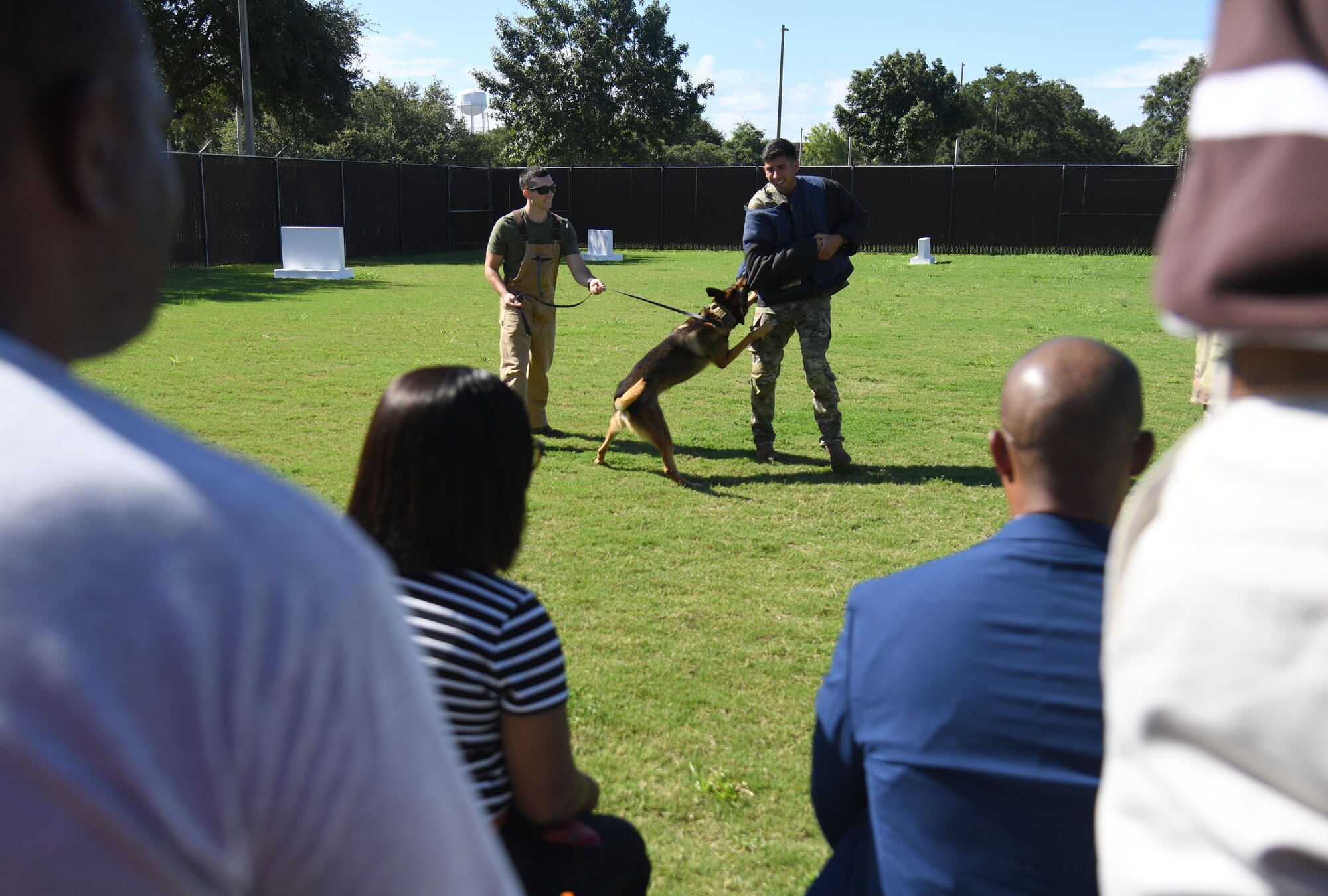 U.S. Air Force Staff Sgt. Dustin Hadsock and Senior Airman Anthony Seretis, 81st Security Forces Squadron military working dog handlers, and Rico, 81st SFS military working dog, perform a demonstration during the Mississippi Educators Tour for Law and Public Safety and Fire Science tour at Keesler Air Force Base, Mississippi, July 27, 2022. More than 30 educators also toured the Keesler Fire Department and received an 81st SFS virtual reality training demonstration. (U.S. Air Force photo by Kemberly Groue)