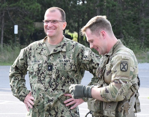 Rear Admiral Eric L. Peterson, deputy commander of Naval Medical Forces Atlantic, speaks with Staff Sgt. Nate Carey, a flight paramedic with 3rd General Support Aviation Battalion, 10th Combat Aviation Brigade, at the start of a training exercise July 21 outside Bridgewater-Vaccaro Medical Simulation Training Center (MSTC) at Fort Drum. Roughly 60 Navy hospital corpsmen participated in Operation Commanding Force, the annual two-week training exercise. The culminating event included tactical field care and medical evacuation procedures with reservists going through a litter obstacle course. (Photo Credit: Michael Strasser)