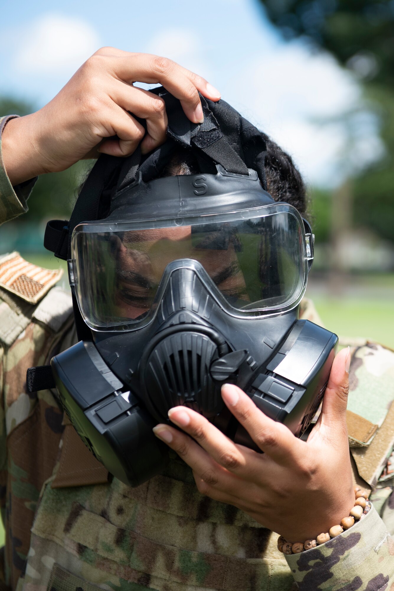 Senior Airman Selena Acosta, 374th Civil Engineer Squadron emergency management journeyman, puts on a gas mask during a chemical, biological, radioactive and nuclear site survey training at the Sagami General Depot, Japan. Acosta and an emergency management team that included the 188th Civil Engineer Squadron from Ebbing Air National Guard Base, Arkansas, performed various CBRN checks to simulate actions needed to clear a landing zone. (U.S. Air Force photo by Tech. Sgt. Joshua Edwards)