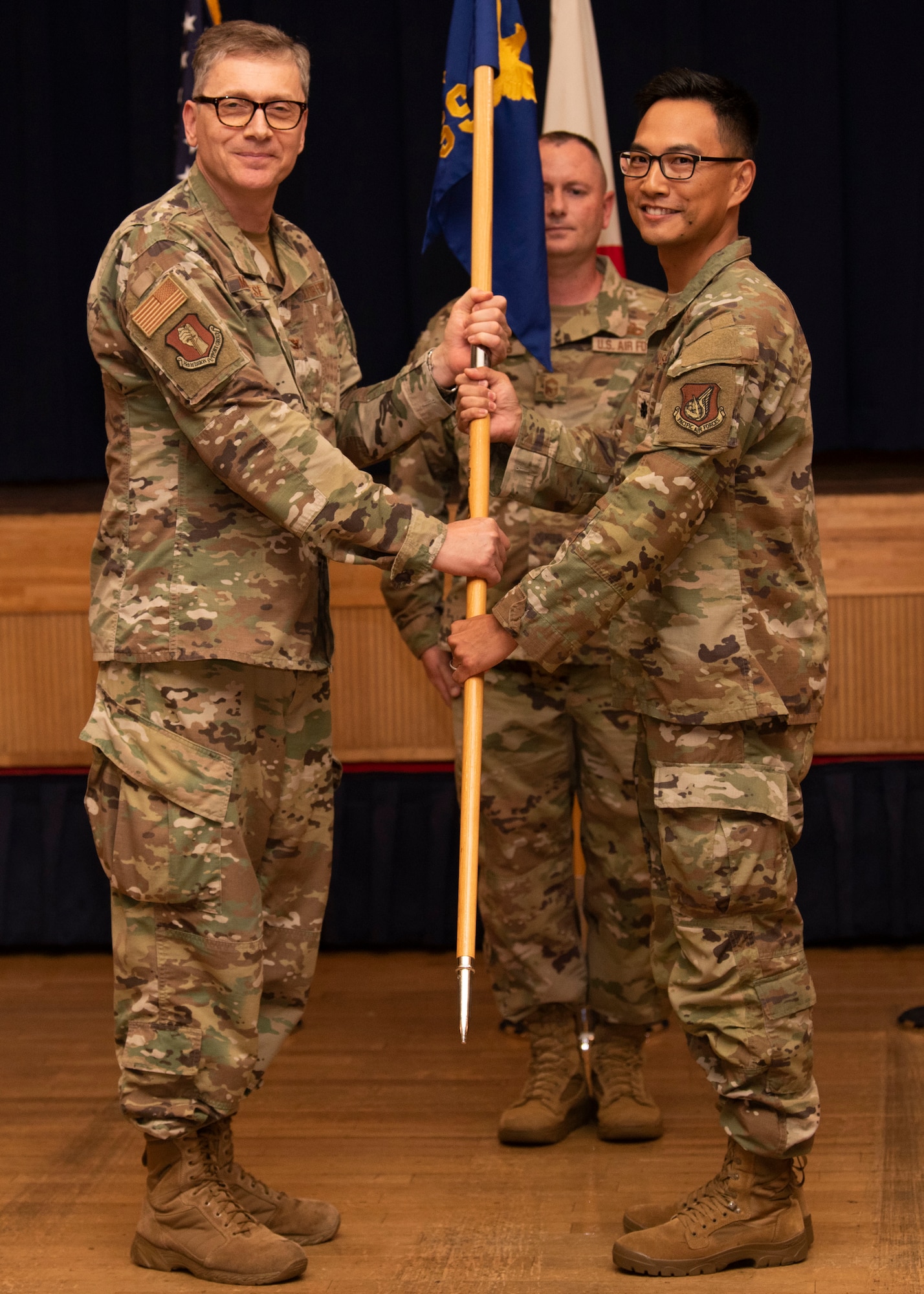 People in uniform perform an assumption of command indoors