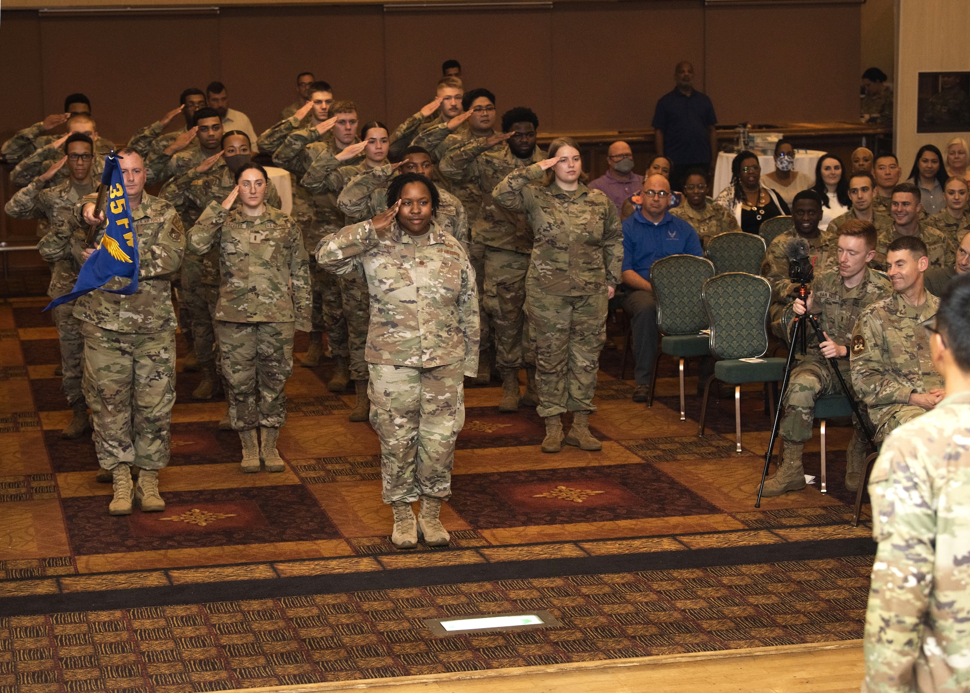 People in uniform perform an assumption of command indoors