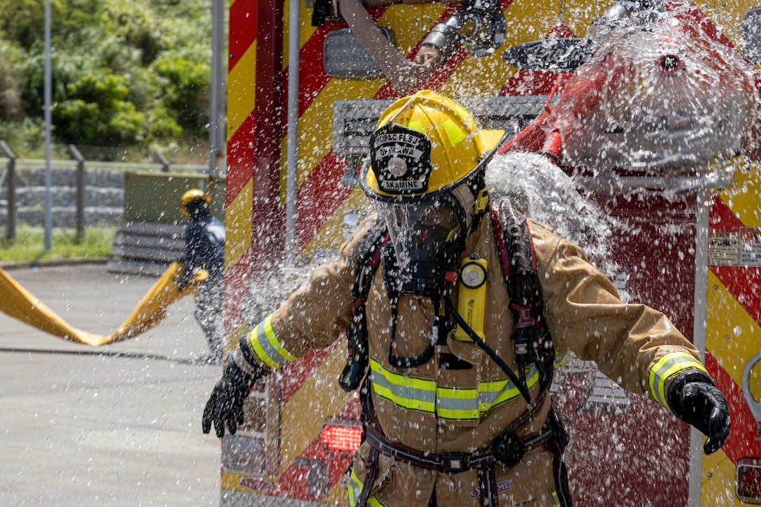 A firefighter with Marine Corps Installations Pacific Fire and Emergency Services conducts a wash down procedure during a Hazardous Materials training exercise on Camp Hansen, Okinawa, Japan, June 27, 2022. The HAZMAT training included multiple simulated victims in a hazardous environment while neutralizing the contaminated area. MCIPAC F&ES is a regional fire department that operates eight fire stations across Japan and provides services to installations including fire suppression, technical rescue, hazardous materials, emergency medical, fire protection and prevention. (U.S. Marine Corps photo by Lance Cpl. Thomas Sheng)