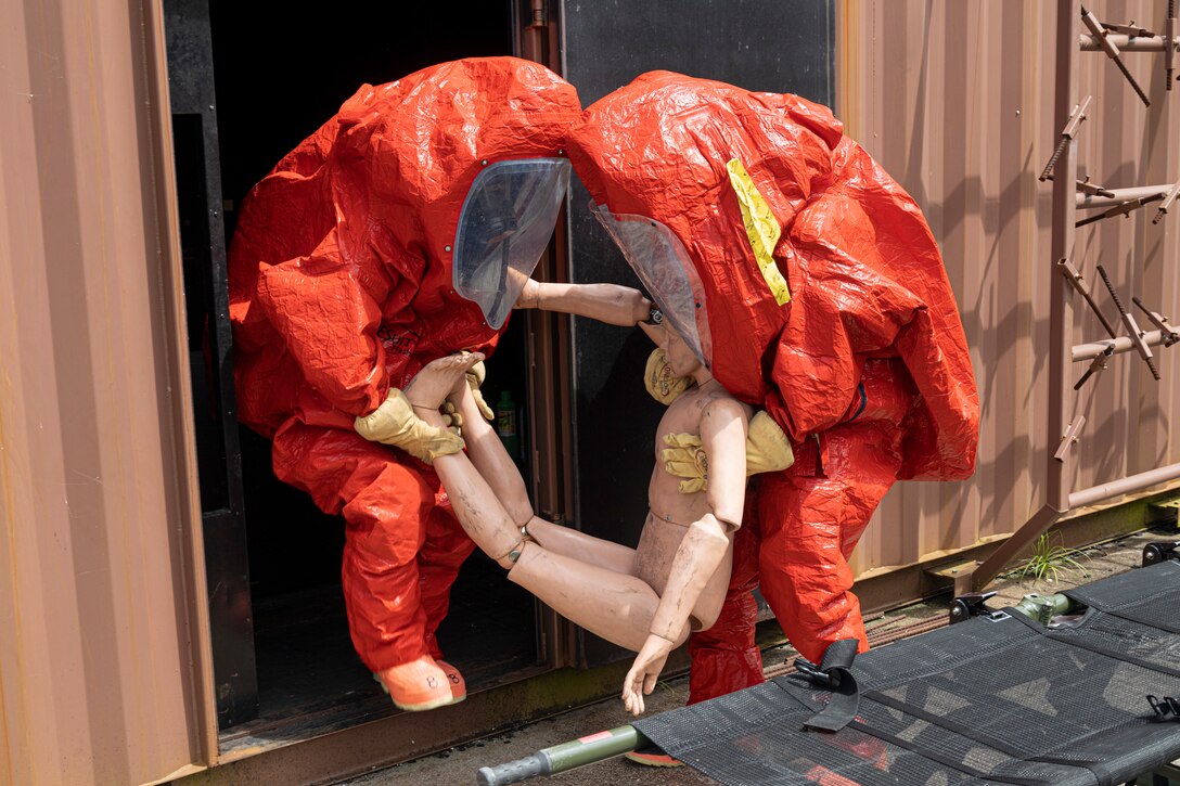 Firefighters with Marine Corps Installations Pacific Fire and Emergency Services assist a simulated victim out of a building during a Hazardous Materials training exercise on Camp Hansen, Okinawa, Japan, June 27, 2022. The HAZMAT training included multiple simulated victims in a hazardous environment while neutralizing the contaminated area. MCIPAC F&ES is a regional fire department that operates eight fire stations across Japan and provides services to installations including fire suppression, technical rescue, hazardous materials, emergency medical, fire protection and prevention. (U.S. Marine Corps photo by Lance Cpl. Thomas Sheng)