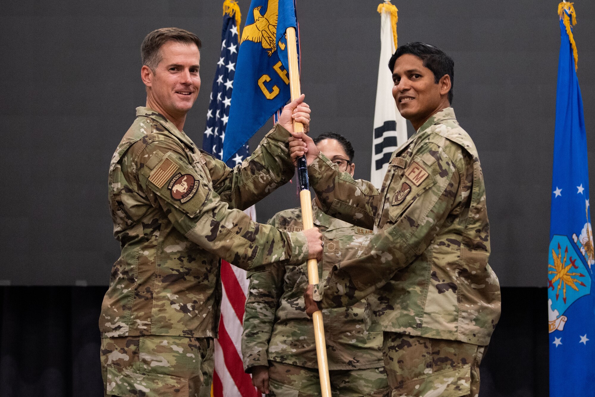 Col. Joshua Wood, 51st Fighter Wing commander, passes the guidon to Maj. Brett Ramnarine, 51st Comptroller Squadron newly appointed commander, during the squadron’s assumption of command ceremony at Osan Air Base, Republic of Korea, July 29, 2022.