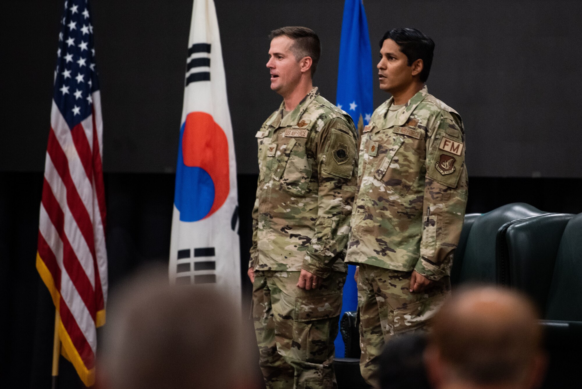 Col. Joshua Wood, 51st Fighter Wing commander, and Maj. Brett Ramnarine, 51st Comptroller Squadron newly appointed commander, sing the U.S. Air Force Song during the squadron’s assumption of command ceremony at Osan Air Base, Republic of Korea, July 29, 2022.