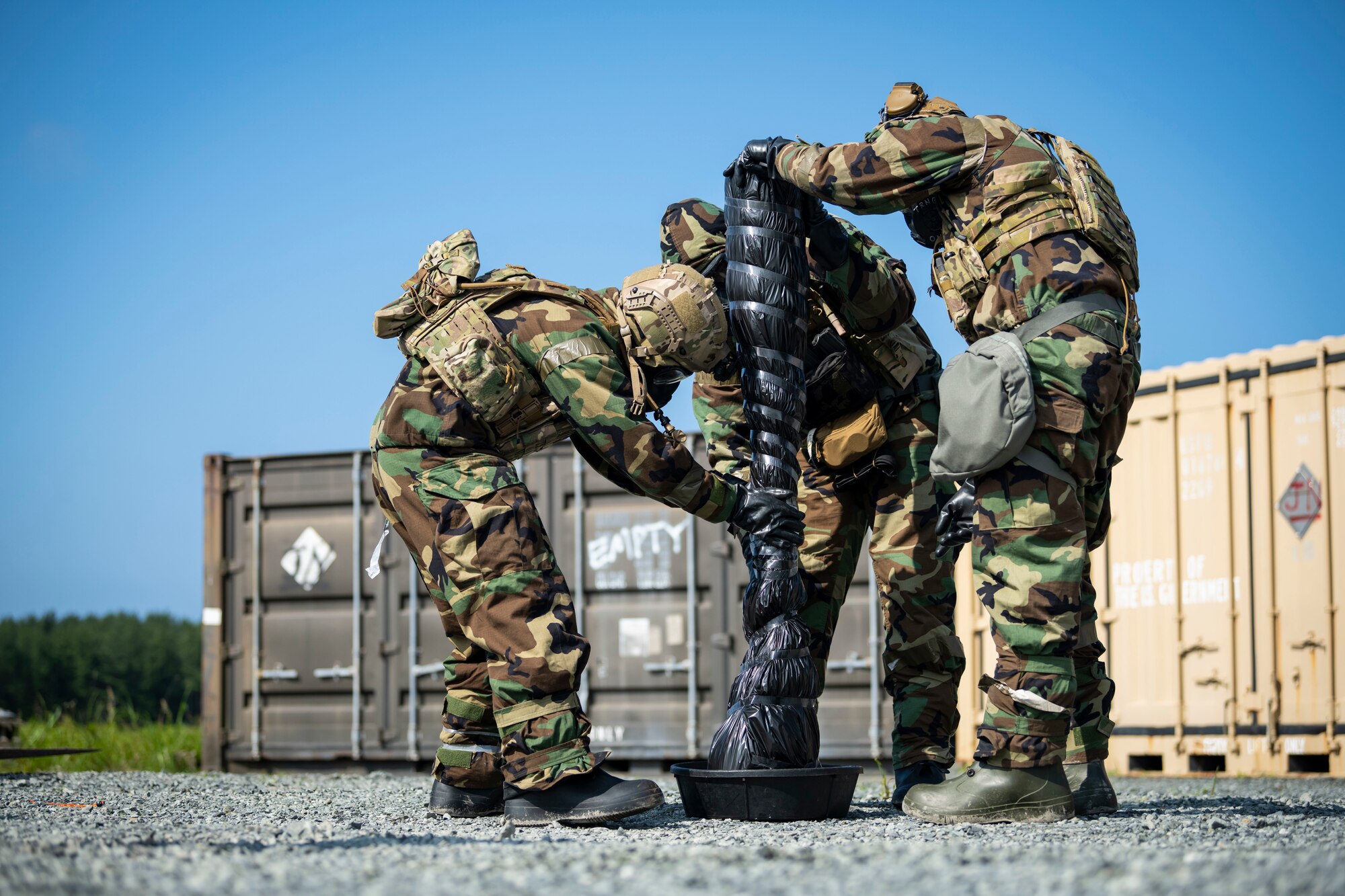 U.S. military members in chemical gear cover a chemical weapon.