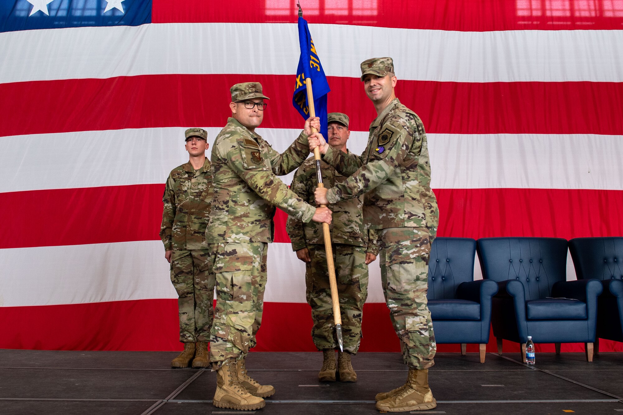 U.S. Air Force Col. Jason Mitchell, 31st Maintenance Group commander, left, takes the official squadron guidon from Maj. Timorthy Aanerud, 31st Aircraft Maintenance Squadron departing commander