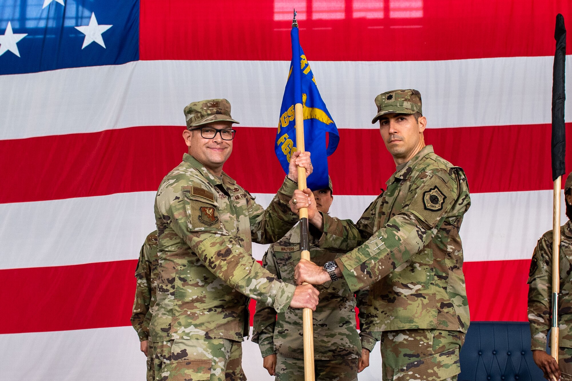 U.S. Air Force Col. Jason Mitchell, 31st Maintenance Group commander, left, presents the 555th Fighter Generation Squadron guidon to U.S. Air Force Lt. Col. David Liberti, 555th FGS incoming commander