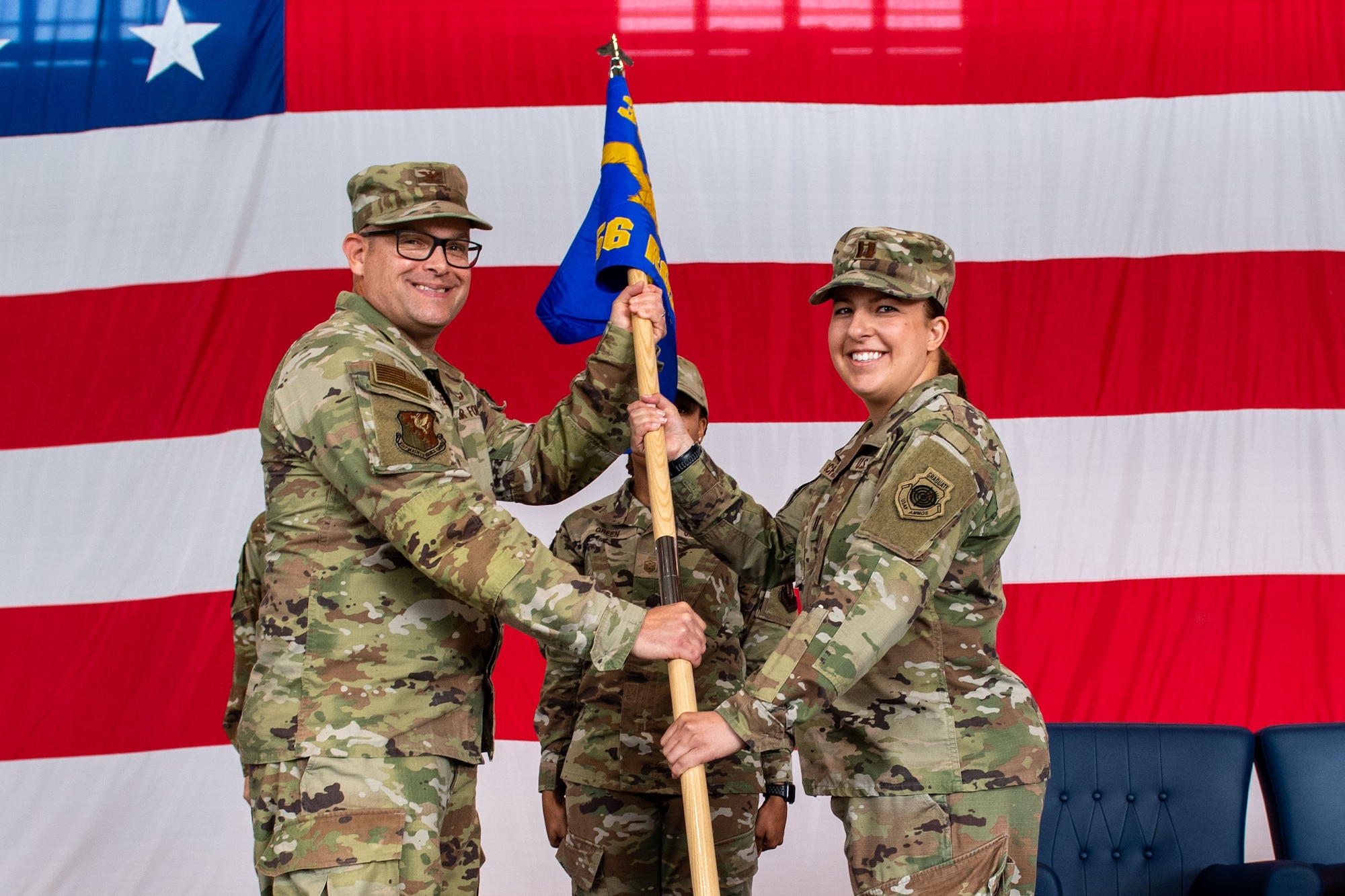 U.S. Air Force Col. Jason Mitchell, 31st Maintenance Group commander, left, presents the 56th Rescue Generation Squadron guidon to U.S. Air Force Capt. Casey Schindling, 56th RGS incoming commander