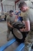 Army Reserve Spc Jacob Chisenall, left, assigned to the 390th Engineer Company, 412th Theater Engineer Command based in Chattanooga, Tenn., and fellow company Soldier, Pfc. Tyler Kirkland, team up to place a Light Capability Rough Terrain Forklift's tire on a pallet jack during the first-ever Field Maintenance Level Course for the LCRTF at the 88th Readiness Division-operated Draw Yard on Fort McCoy, Wis., July 27, 2022. (U.S. Army Reserve photo by Sgt. 1st Class Clinton Wood, 88th Readiness Division).