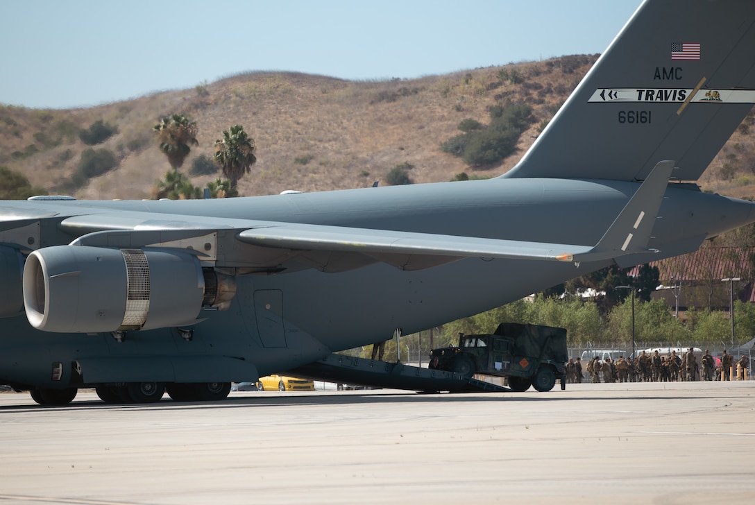 U.S. Marines with 3rd Battalion, 5th Marine Regiment, 1st Marine Division and U.S. Airmen with 21st Airlift Squadron, 60th Air Mobility Wing load a Humvee onto a U.S. Air Force C-17 Globemaster III aircraft during a joint training exercise on Marine Corps Air Station Camp Pendleton, California, July 25, 2022. This exercise included aircraft from five different U.S. Air Force squadrons and Marines with 3/5, 1st MarDiv to enhance their expeditionary operations in a joint-training environment. This was the first time MCAS Camp Pendleton staged five C-17 Globemaster III aircraft on the air station at one time. (U.S. Marine Corps photo by Cpl. Shaina Jupiter)