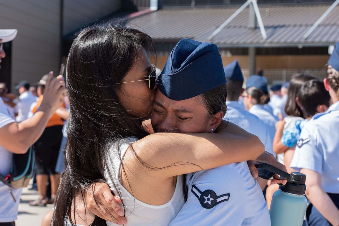 Two women embrace.