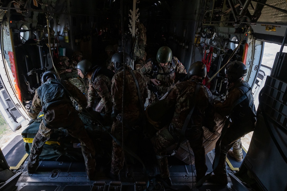 Loadmaster gives hand and arm signal on aircraft