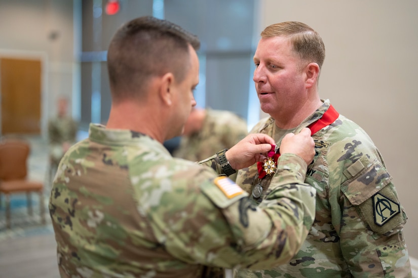 Col. Douglas Copeland, outgoing Project Manager for Soldier Maneuver and Precision Targeting (PM SMPT), receives the Legion of Merit from Brig. Gen. Christopher Schneider, Program Executive Officer (PEO) Soldier, during a relinquishment of charter ceremony held on Fort Belvoir, July 14. The ceremony marked the disestablishment of PM SMPT after more than 20 years of providing Soldiers with capabilities designed to enhance lethality, mobility and survivability. (U.S. Army Photo by Jason Amadi, PEO Soldier Public Affairs)