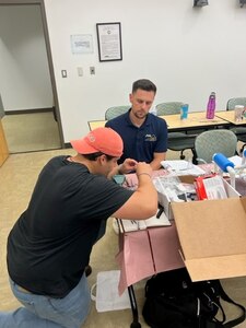 IMAGE: Luis Valcourt-Colon, lead scientist/software developer with the Weapon Control Software Branch at Naval Surface Warfare Center Dahlgren Division, works with Austin Eppenstein, a teacher at Grafton Village Elementary School in Stafford County on the construction of a SeaPerch remotely operated vehicle on July 19 at the University of Mary Washington’s Dahlgren campus.