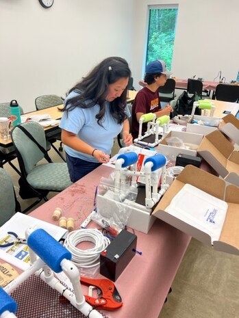 IMAGE: Laura Van Dyk, a teacher at Grafton Village Elementary School in Stafford County and her son J.J. Van Dyk, a student at Stafford High School, construct a SeaPerch remotely operated vehicle during a training conducted by NSWCDD employees July 19 at the University of Mary Washington’s Dahlgren campus.