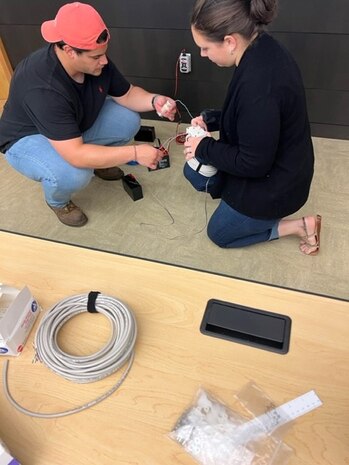 IMAGE: Luis Valcourt-Colon, lead scientist/software developer with the Weapon Control Software Branch at Naval Surface Warfare Center Dahlgren Division, instructs Katie Vukmanic, a teacher at Hartwood Elementary School in Stafford County on the construction of a SeaPerch remotely operated vehicle on July 19 at the University of Mary Washington’s Dahlgren campus.