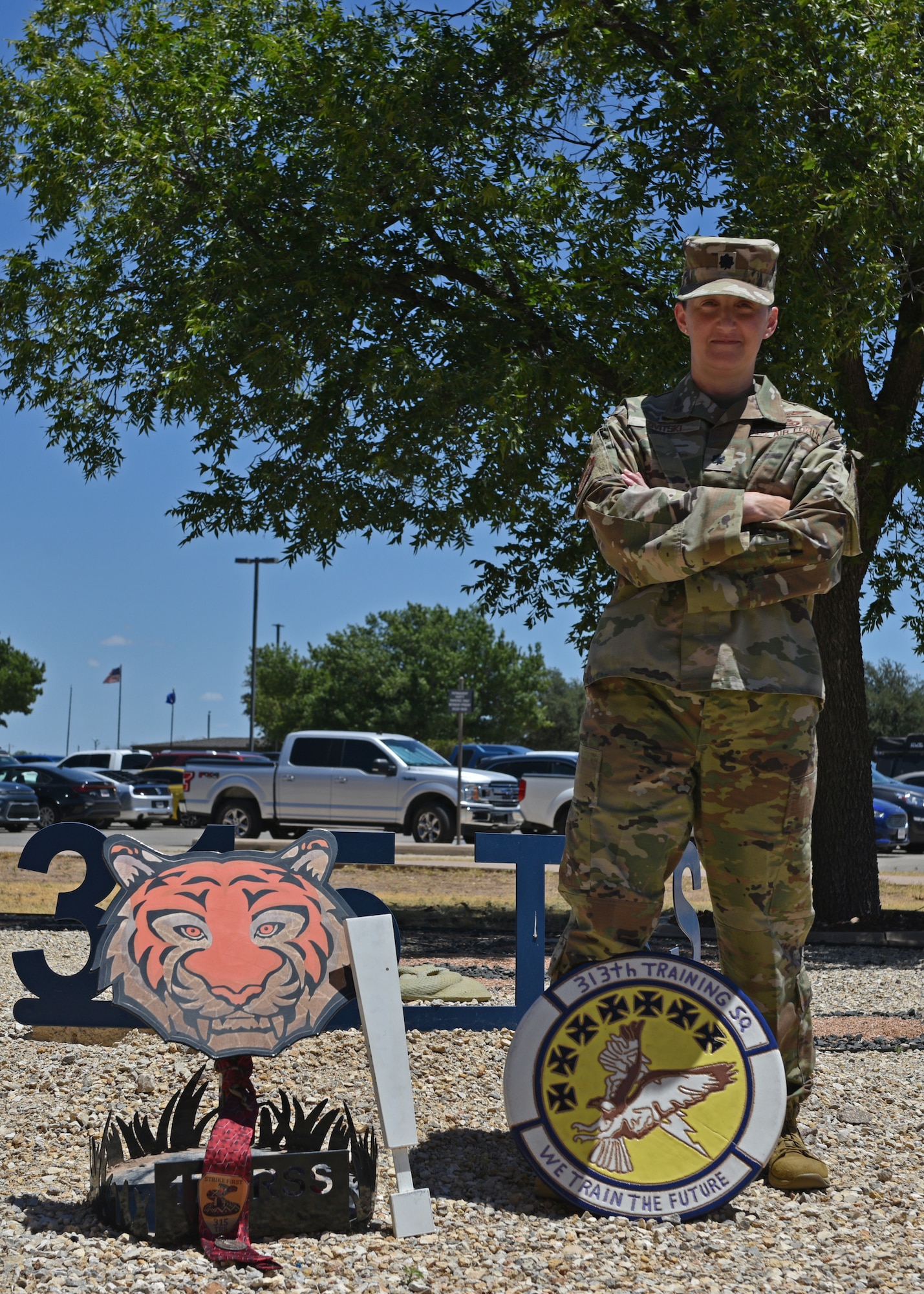 U.S. Air Force Lt. Col. Liane Zivitski, 315th Training Squadron commander, poses for a photo with the spoils of a prank war at Goodfellow Air Force Base, Texas, July 25, 2022. The squadrons had a prank war during “shark week” to boost morale . (U.S. Air Force photo by Senior Airman Ashley Thrash)