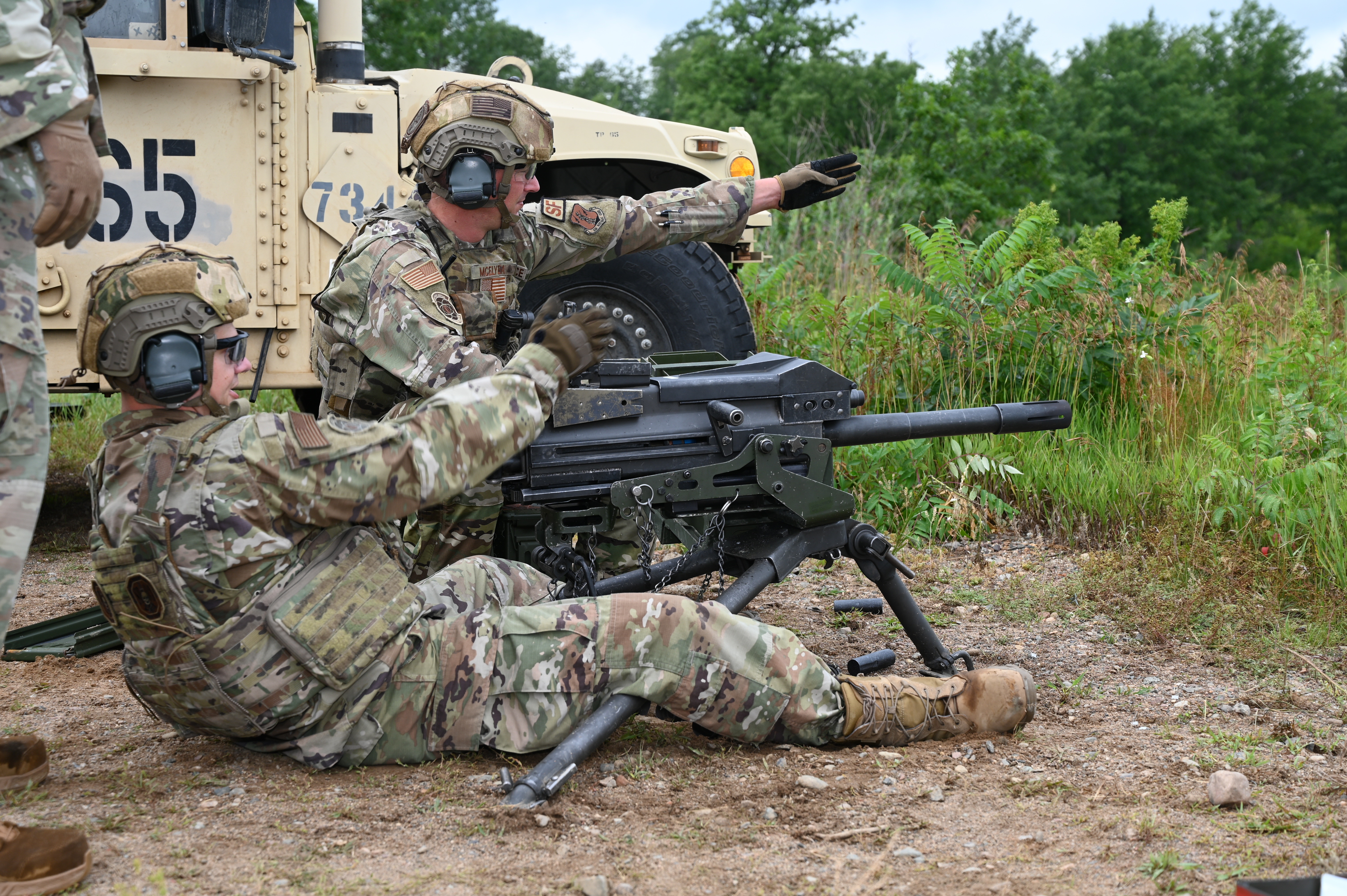 U.S. Air Force members of the 219th Security Forces Squadron Tech. Sgt. Shawn Mcelyea points while providing overwatch as Tech. Sgt. Kasey Taylor operates an Mk 19 grenade launcher (pronounced Mark 19) a 40mm belt-fed automatic grenade launcher during stationary turret training held at Camp Ripley Minnesota July 26, 2022. Airman received both stationary and mobile training on the Mark 19 as part of their qualify course to prepare them for real world missile fields and deployments. (U.S. Air National Guard Photo by Senior Airman Christa Anderson)