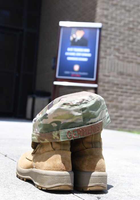 A pair of boots and hat are on display during a remembrance ceremony for U.S. Air Force Airman Daniel Germenis outside of Thompson Hall at Keesler Air Force Base, Mississippi, July 28, 2022. Germenis, who was assigned to the 336th Training Squadron, was remembered by members of the 81st Training Group on the one year anniversary of his passing. (U.S. Air Force photo by Kemberly Groue)