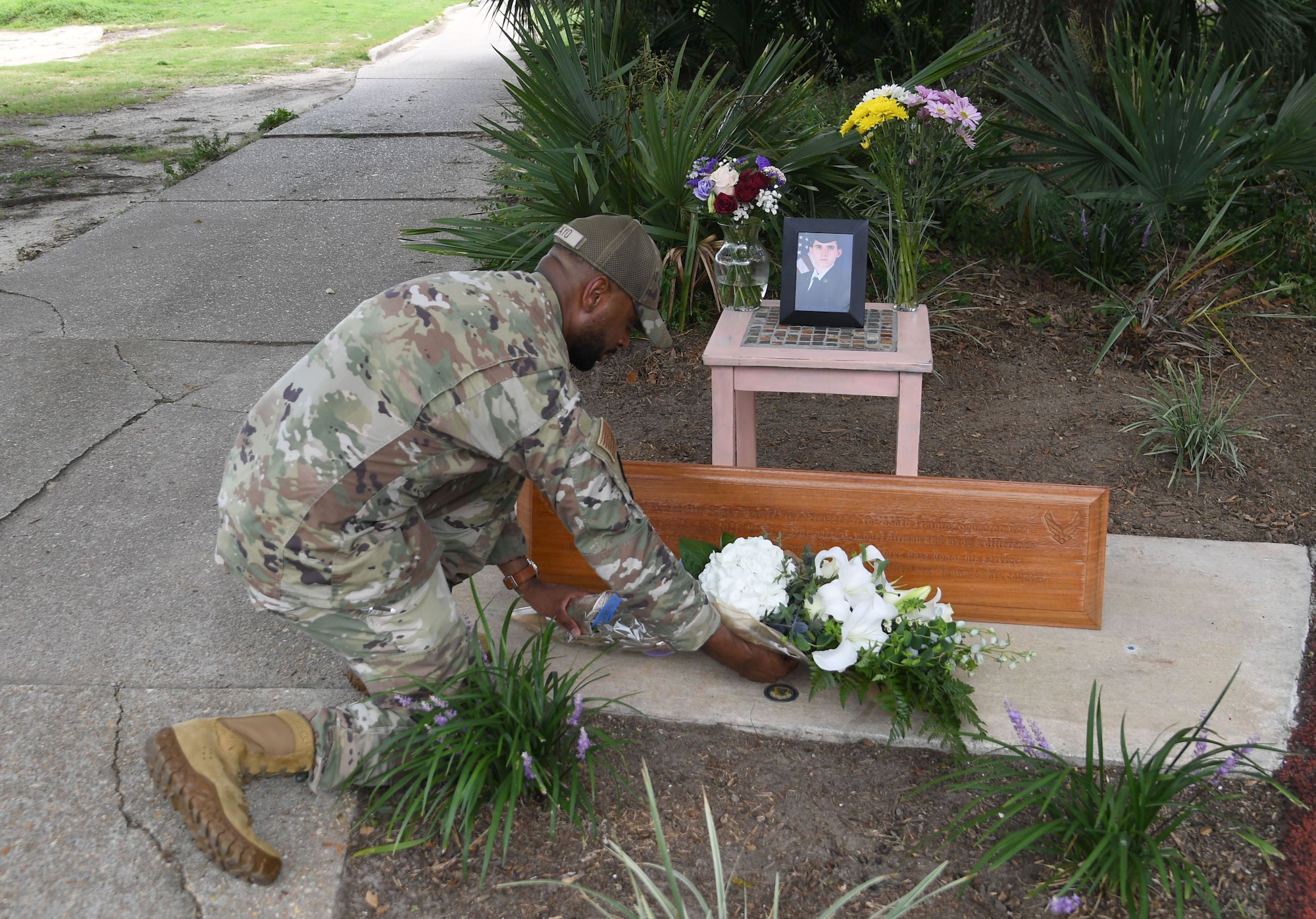 U.S. Air Force Tech. Sgt. Louis Lacayo, 336th Training Squadron instructor, places a bouquet of flowers during a remembrance ceremony for Airman Daniel Germenis at Keesler Air Force Base, Mississippi, July 28, 2022. Germenis, who was assigned to the 336th Training Squadron, was remembered by members of the 81st Training Group on the one year anniversary of his passing. (U.S. Air Force photo by Kemberly Groue)