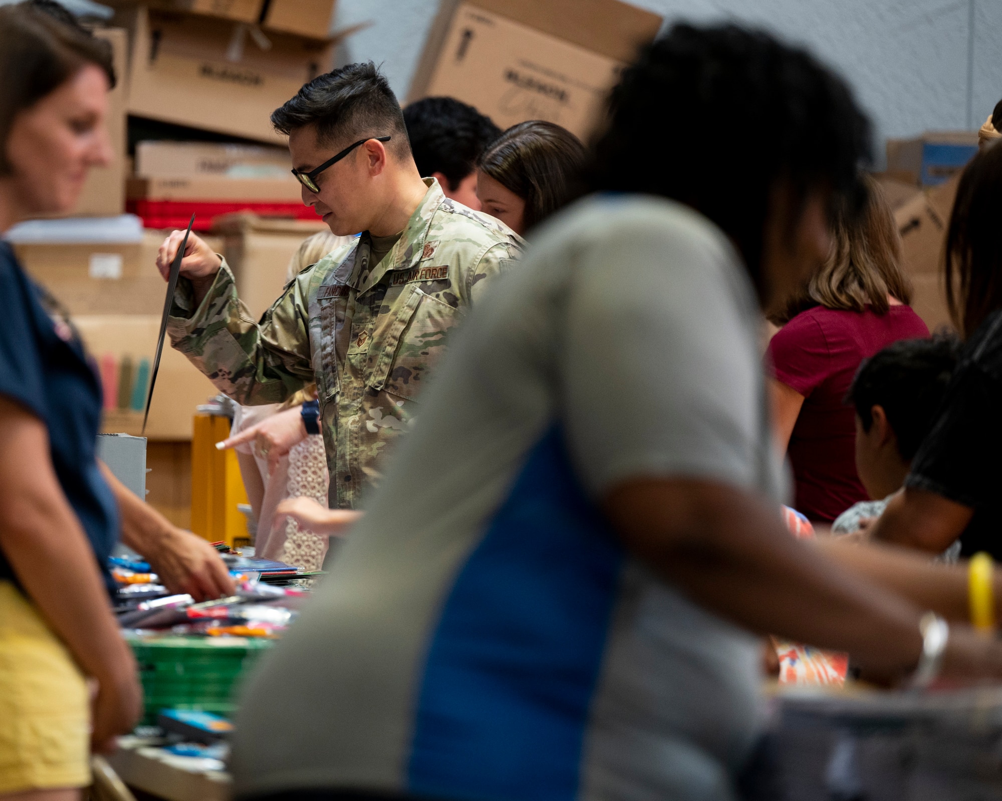 Photo of people giving out and gathering school supplies.