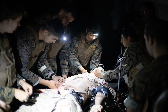 U.S. Navy Sailors with Bravo Surgical Company, 3d Medical Battalion, 3d Marine Logistics Group, assess and treat a simulated casualty during a nighttime medical treatment training event, Marine Corps Base Hawaii, July 19, 2022. The training was conducted in order to familiarize members of Bravo Surgical Company with patrolling, resuscitation, surgical treatment, and evacuation of injured service members in a nighttime environment. (U.S. Marine Corps photo by Cpl. Brandon Aultman)