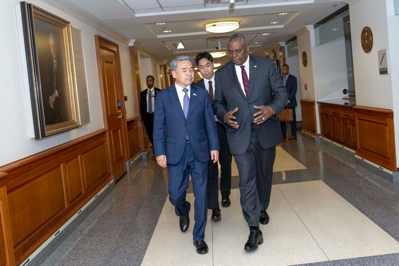 Secretary of Defense Lloyd J. Austin III walks along a Pentagon hallway with South Korea's Defense Minister and others.
