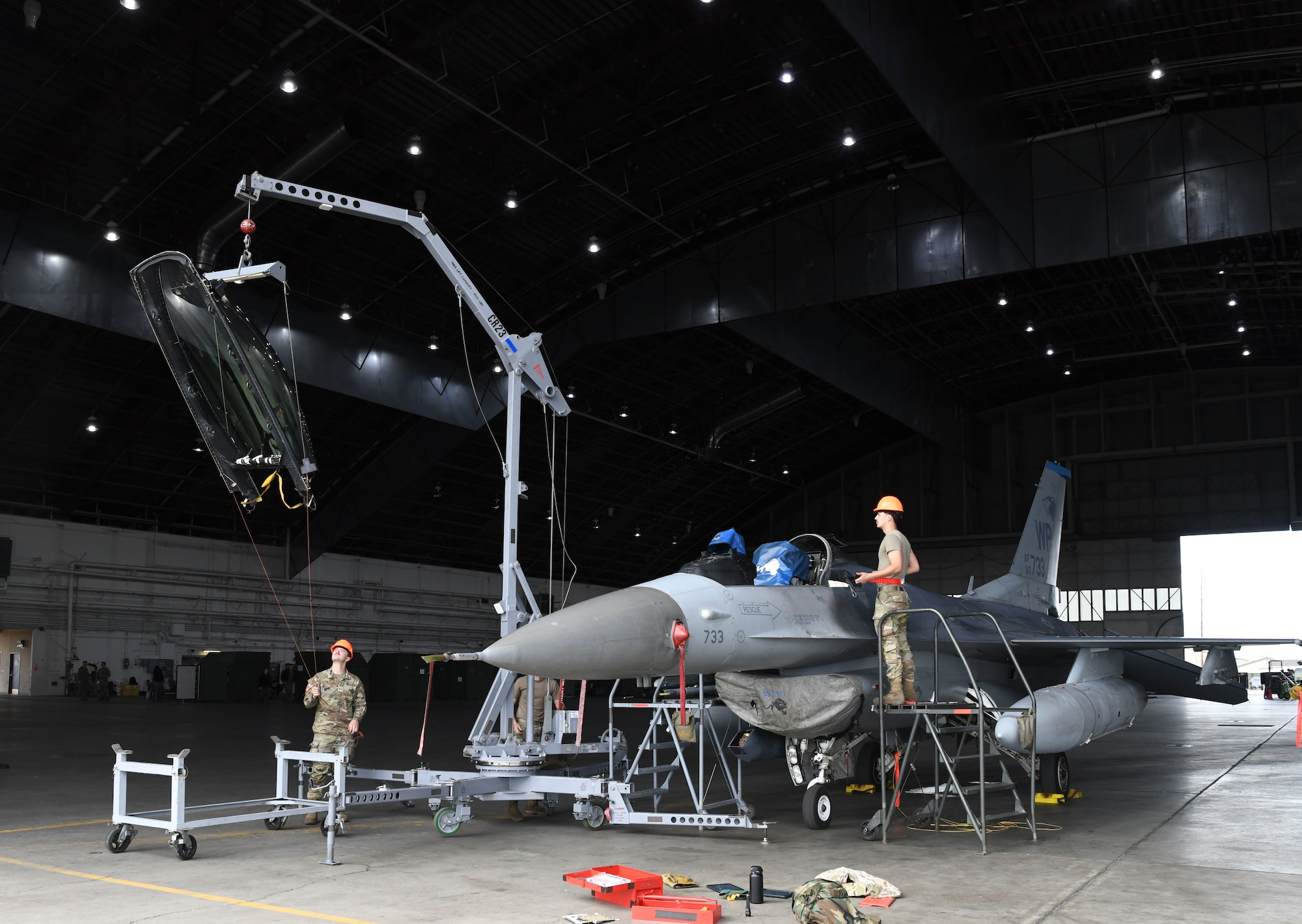 U.S. Air Force Staff Sgt. Brendan Ridley, left, 35th Fighter Generation Squadron aircrew egress technician, and Senior Airman Shawn McGraw, 8th Maintenance Squadron fuels technician, perform an F-16 Fighter Falcon canopy replacement during Red Flag Alaska 22-3 at Eielson Air Force Base, Alaska, July 28, 2022.