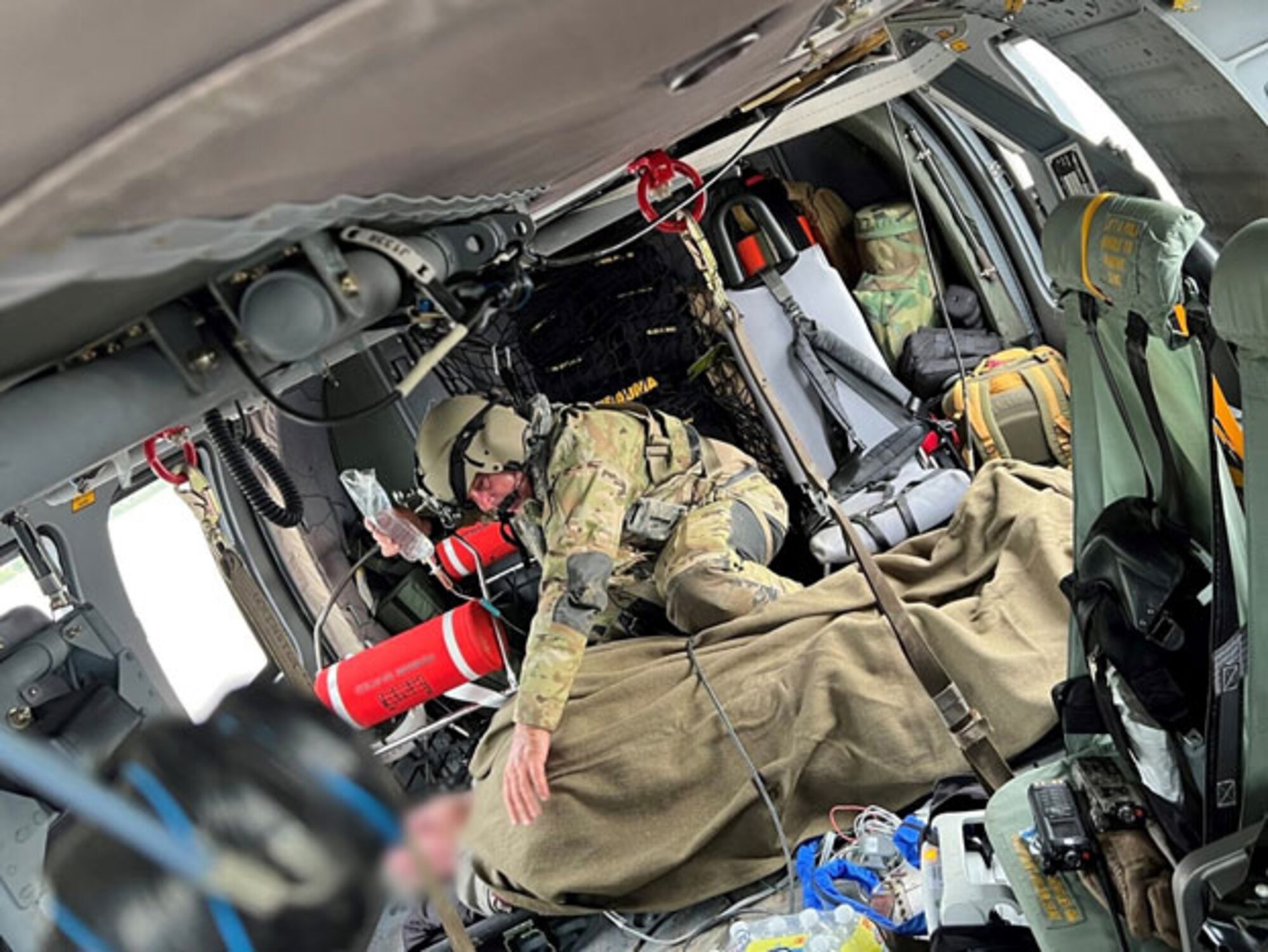 A Tennessee Army National Guard Soldier comforts a patient rescued from the flooding in eastern Kentucky while being flown to a hospital July 28, 2022. The Tennessee National Guard sent five Black Hawk helicopters and crews to assist in search and rescue efforts.