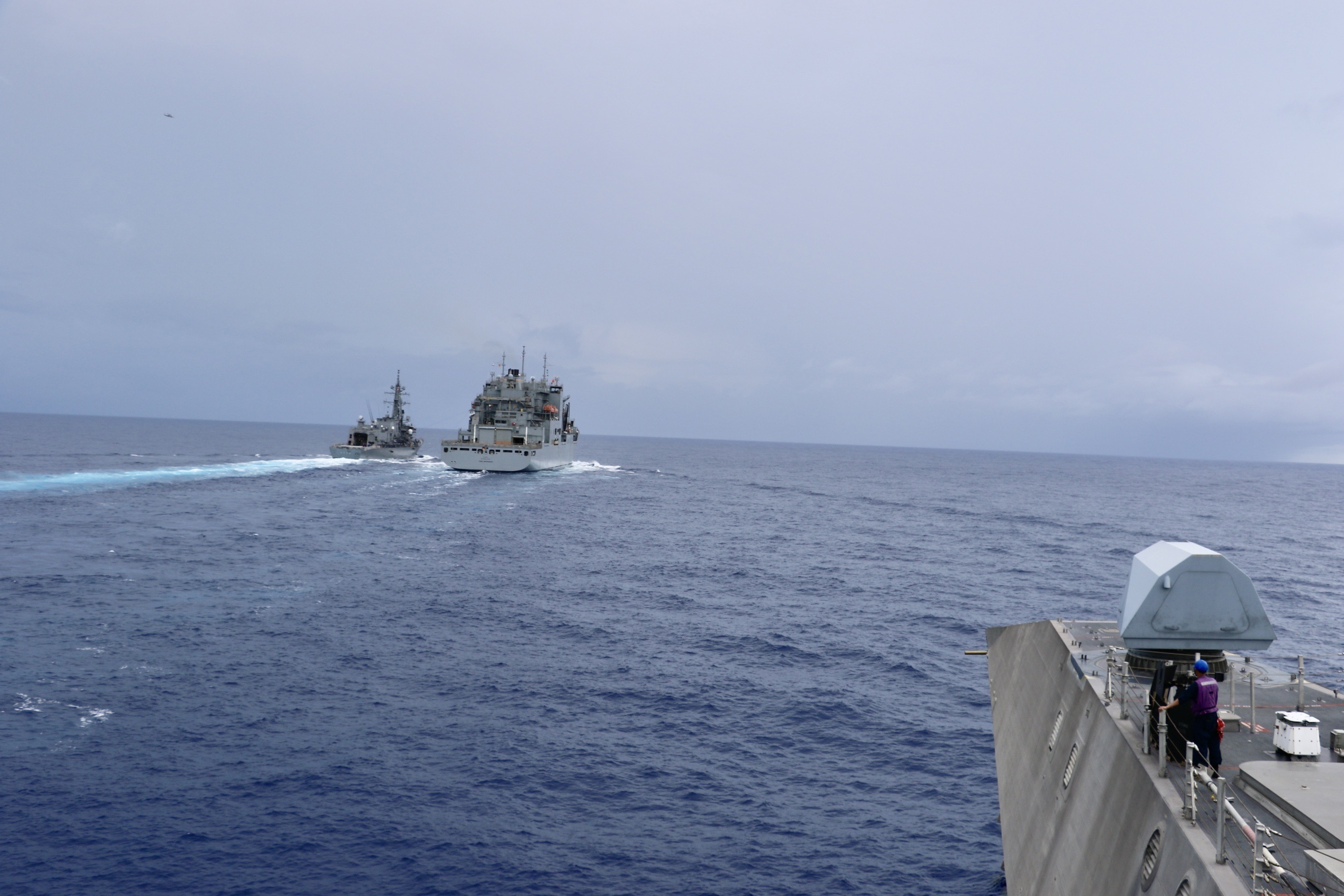 The Independence-variant littoral combat ship USS Jackson (LCS 6) prepares to be received alongside the Military Sealift Command Lewis and Clark-class dry cargo ship USNS Carl Brashear (T-AKE 7), middle, during a replenishment-at-sea evolution in the Philippine Sea.