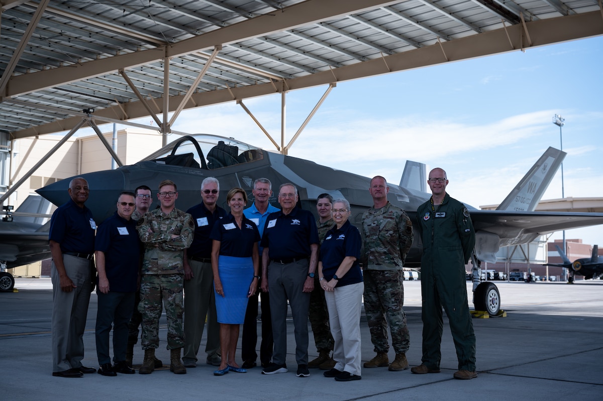 A group of people standing in front of an F-35