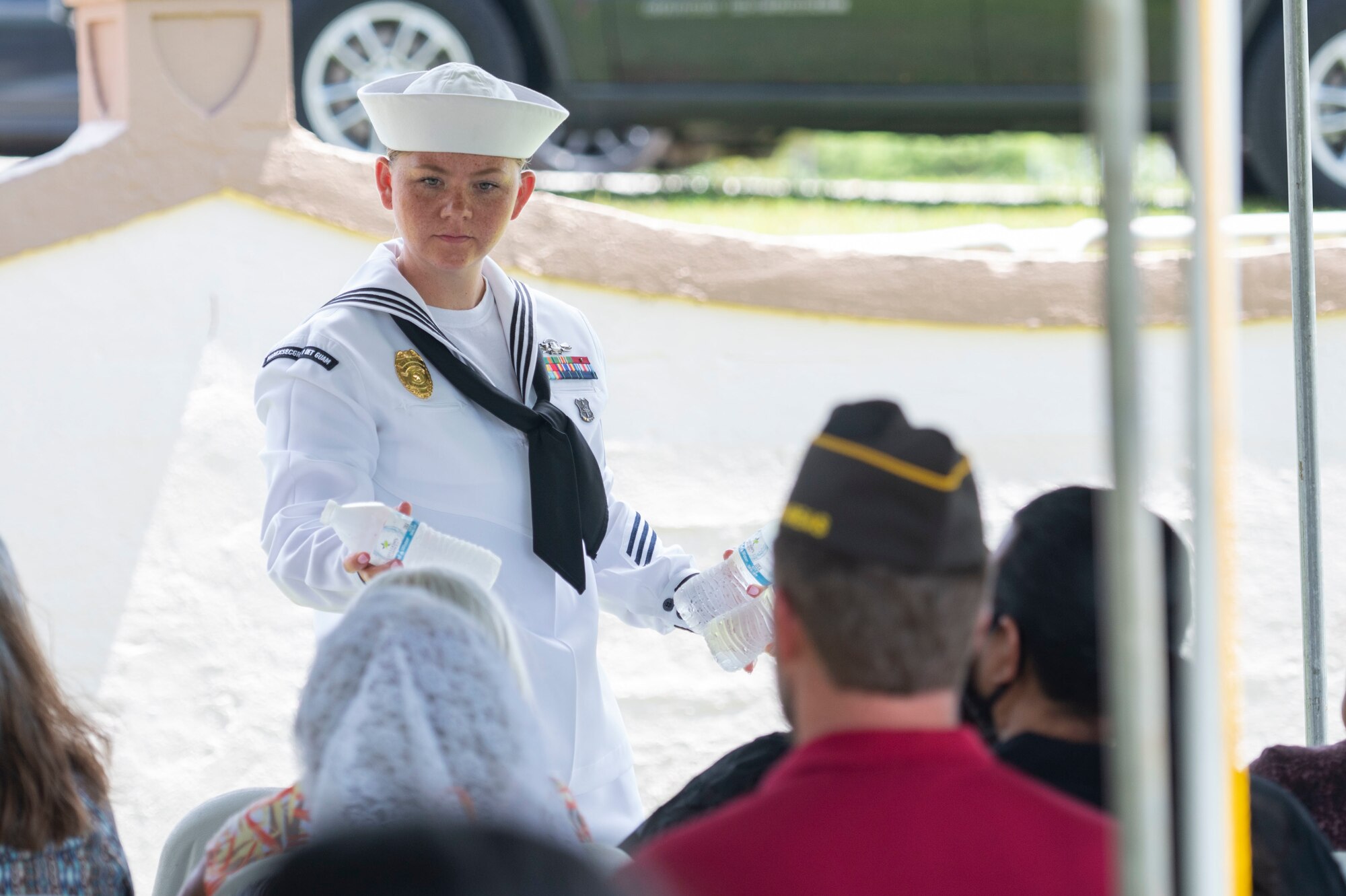 A sailor handing out water bottles