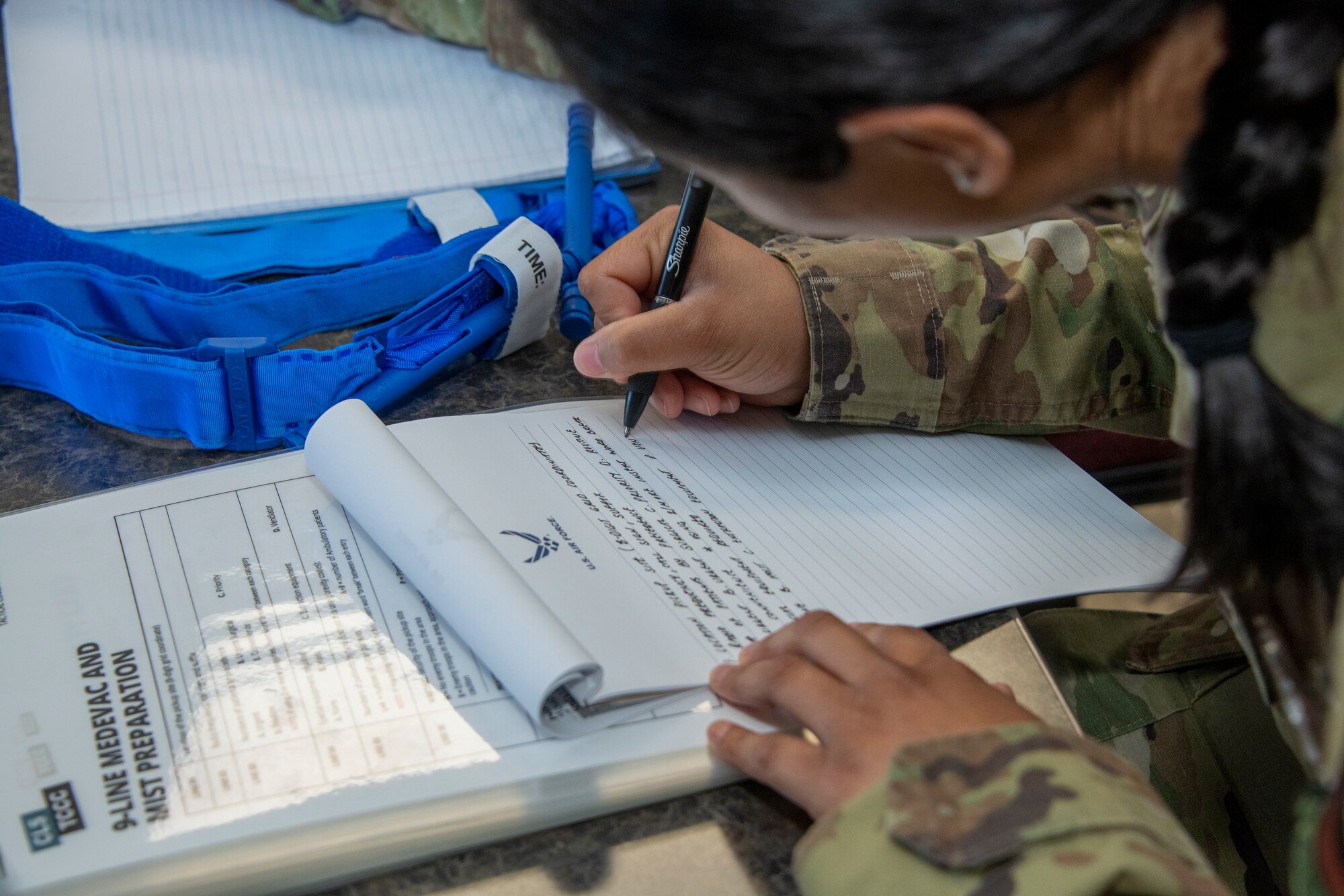 An Airman writes on paper.