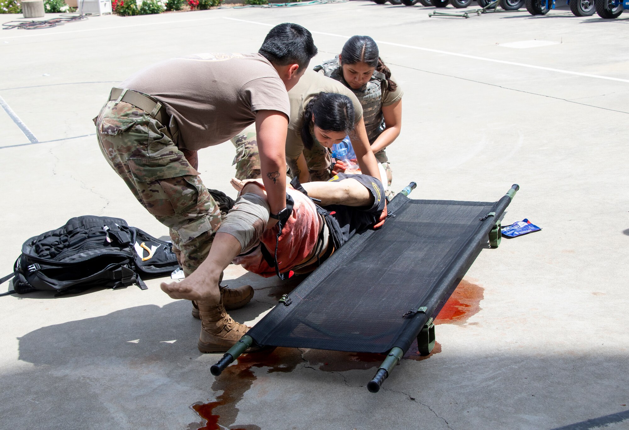 Airmen put a mannequin on a stretcher