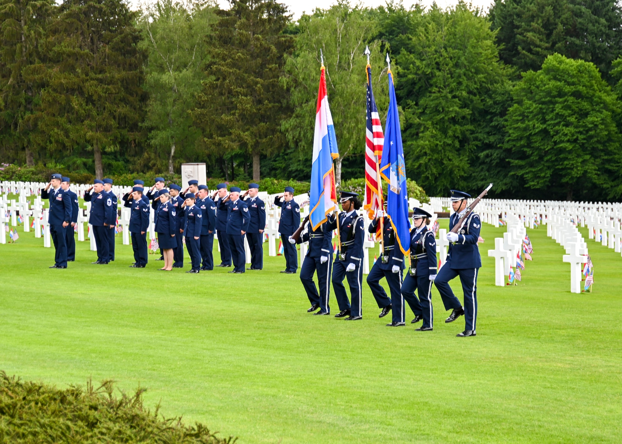 The 786th Force Support Squadron Honor Guard, assigned to Ramstein Air Base and a detail of Airmen assigned to the 726th Air Mobility Squadron, Spangdahlem AB, Germany, salute during a Memorial Day event at the Luxembourg American Military Cemetery in Luxembourg, May 28, 2022. The 726th AMS has historically been the Honor Platoon for this event.  (U.S. Air Force photo by Airman 1st Class Jessica Sanchez-Chen)