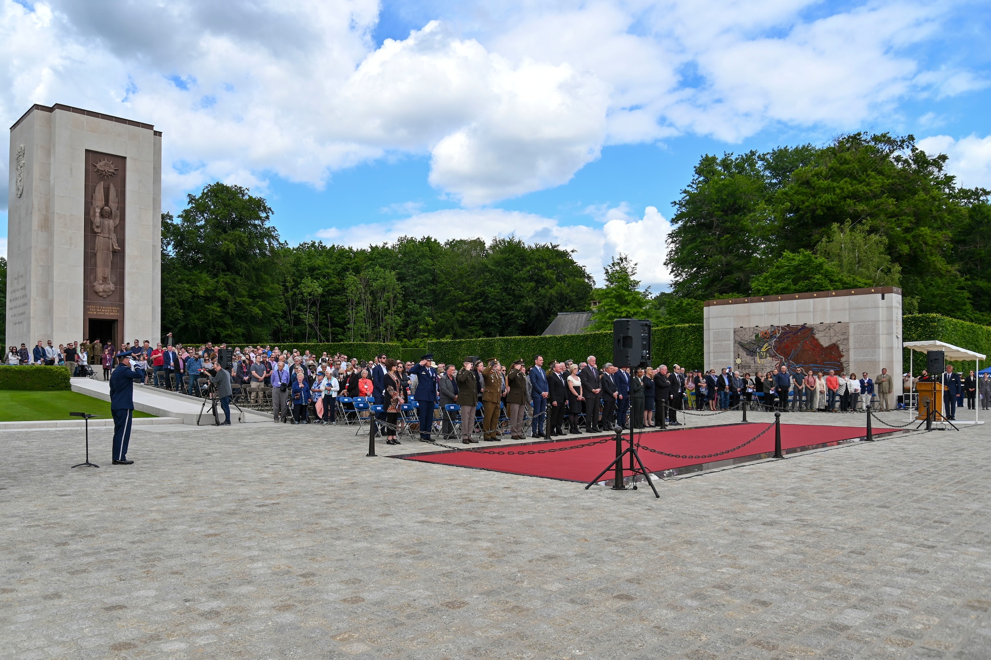 Spectators stand and salute during a Memorial Day event at the Luxembourg American Military cemetery in Luxembourg on May 28, 2022. Hundreds of military members and military supporters joined together to pay their respects to the men and women who lost their lives during World War II. (U.S. Air Force photo by Airman 1st Class Jessica Sanchez-Chen)